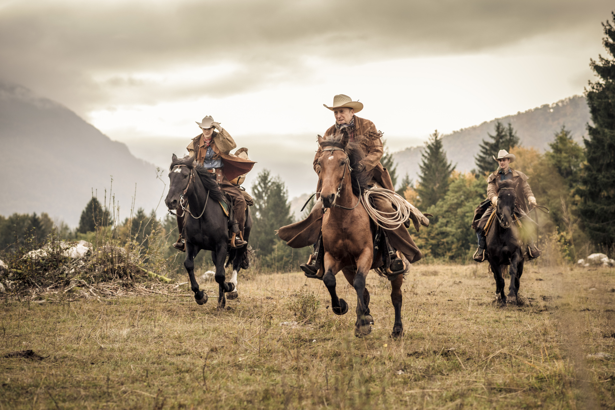 Men and women horseback riding in the mountains